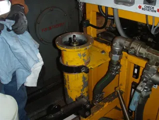 A technician wiping out a yellow Magnom housing opened on a machine